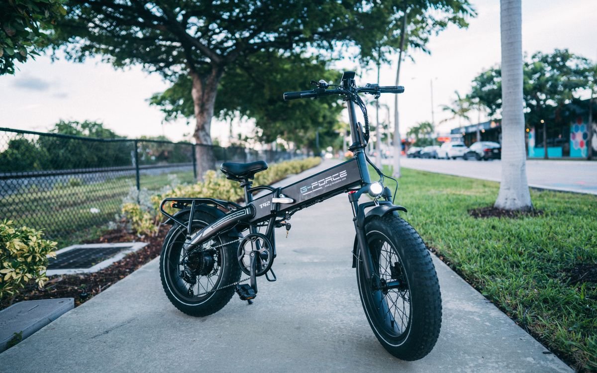 Sleek electric bike parked outdoors surrounded by greenery
